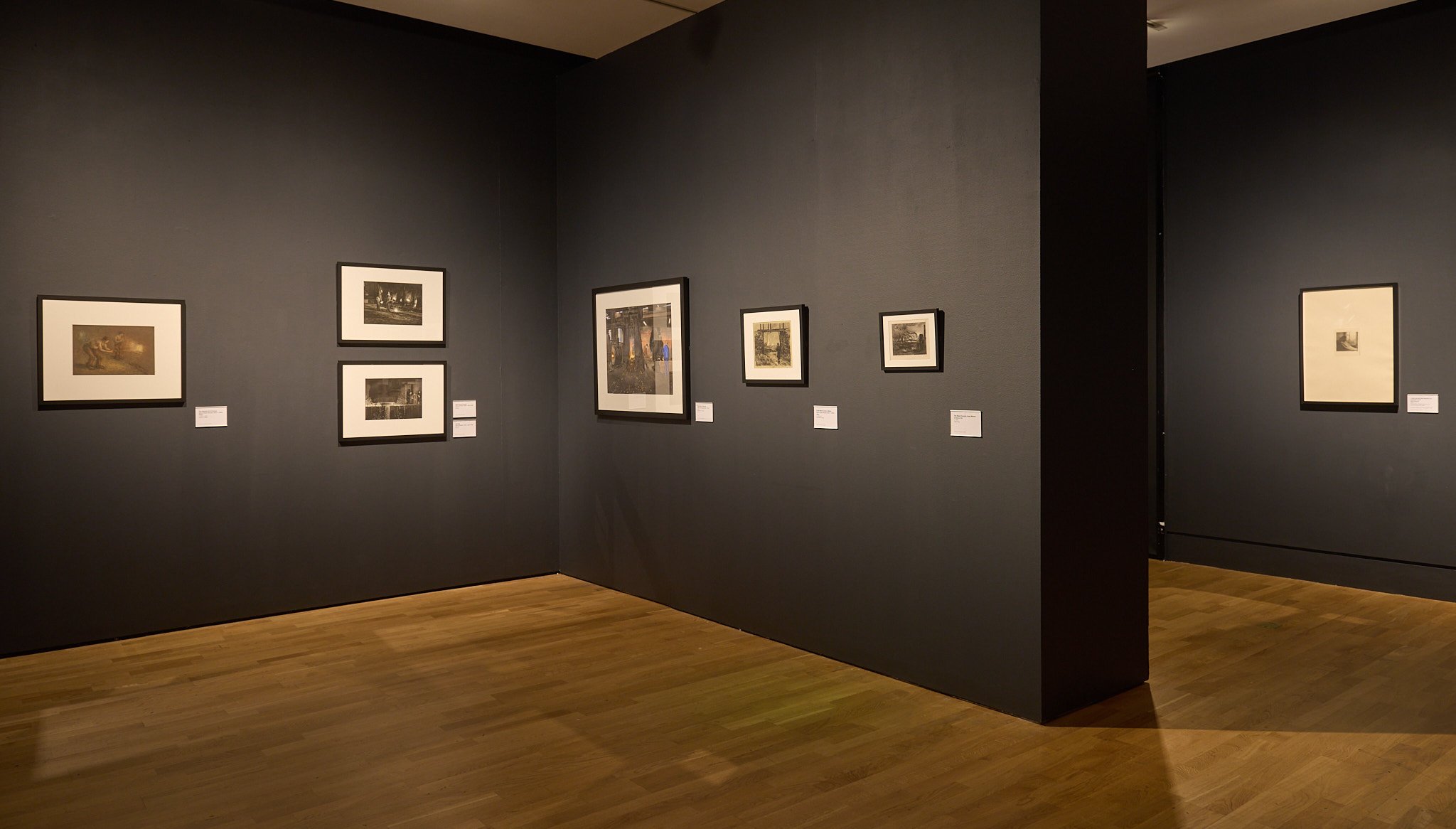 Prints and etchings hung salon-style on dark gallery walls at Wolverhampton Art Gallery.