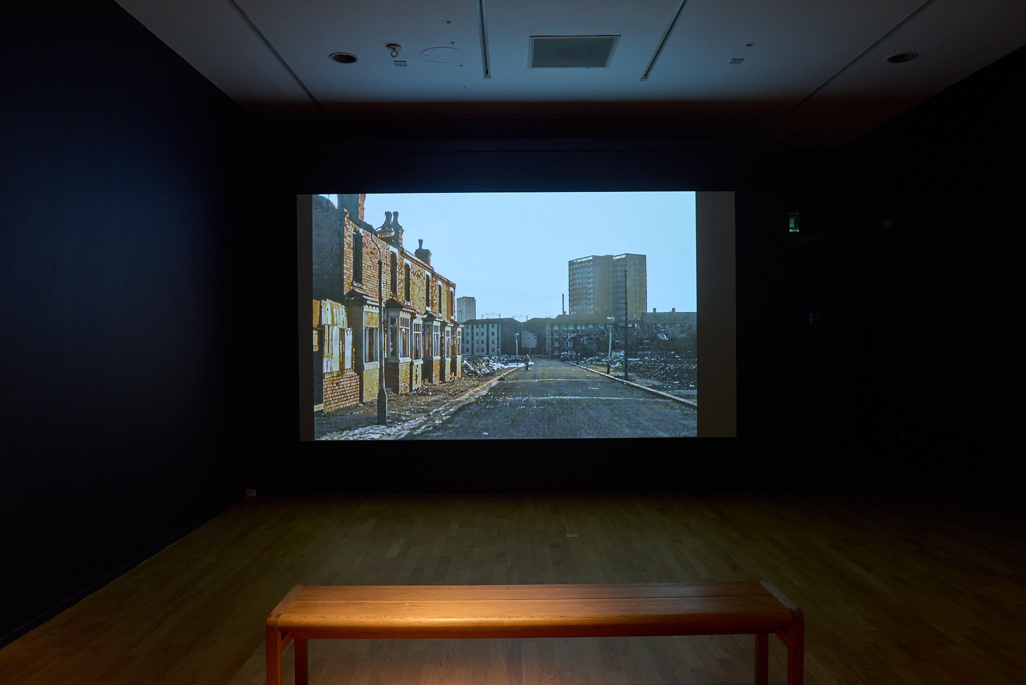 Archival film projected large-scale: terraced houses and tower block, Black Country.
