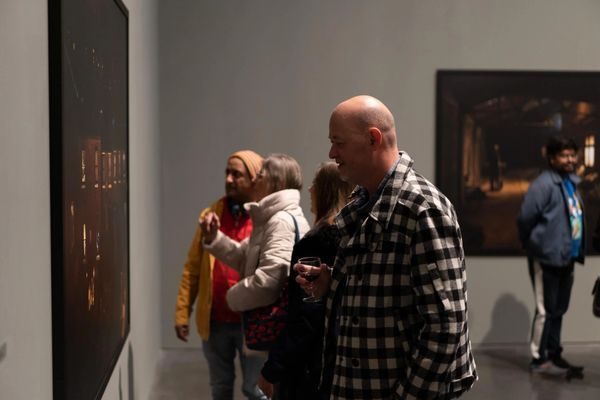 A visitor closely examining one of the Exiles tableaux