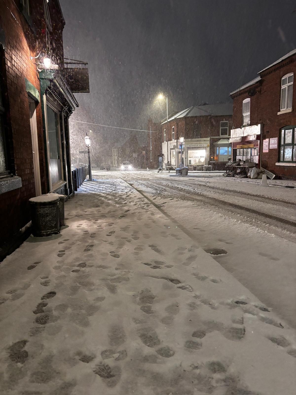 Crew member with lamp in heavy blizzard on set